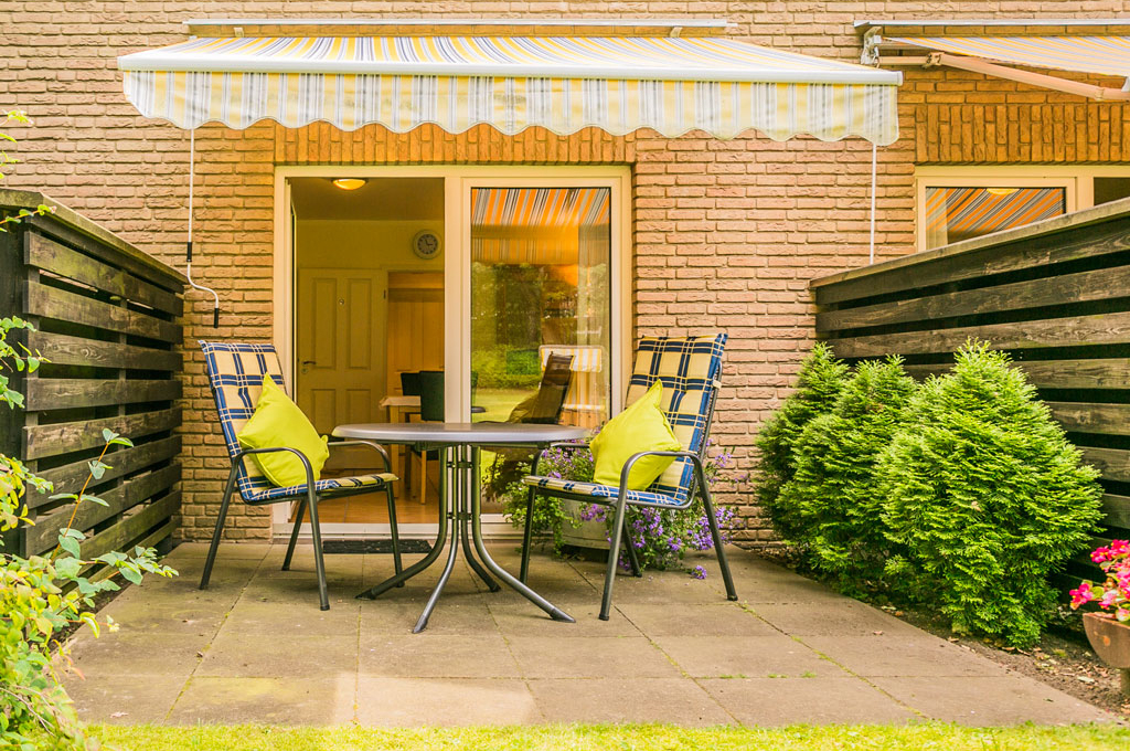 Terrasse eines Apartments im Landhaus Teuteberg in Bad Bevensen mit überdachtem Tisch und zwei Stühlen