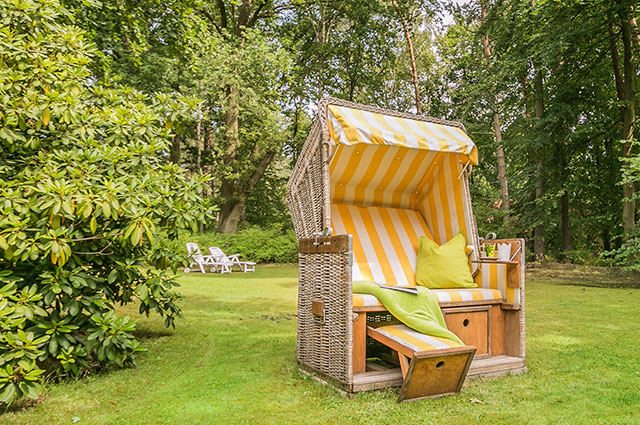 Strandkorb im Garten des Landhauses Teuteberg in Bad Bevensen mit weiteren Liegen im Hintergrund