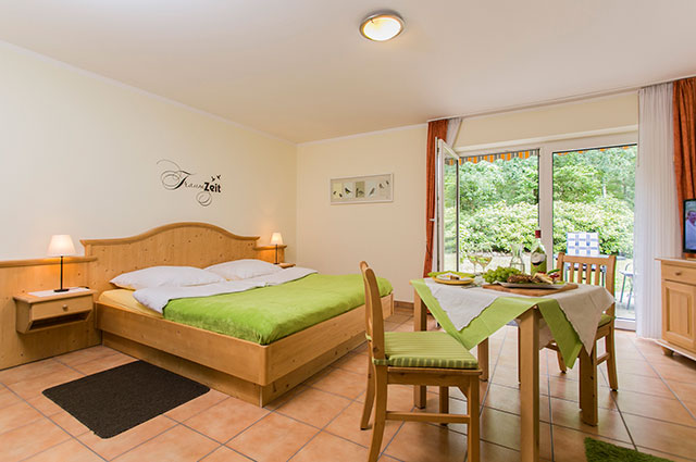 Apartment im Landhaus Teuteberg in Bad Bevensen mit Bett, separatem Tisch, Stühlen, Fernseher und Terrasse